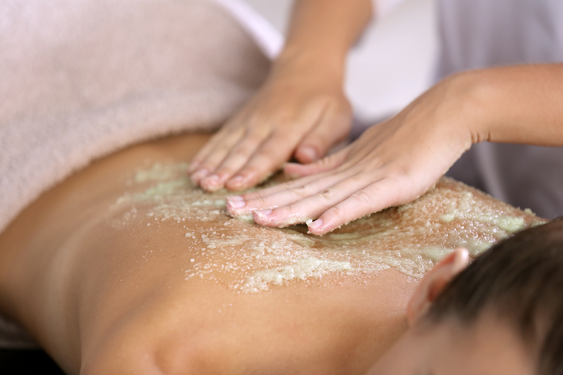 Young Woman Receiving Scrub Massage in Spa Salon